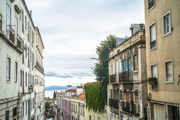 Fototapeta premium historic buildings of the old town of lisbon. Old colorful buildings, narrow streets, historic churches. Cloudy day