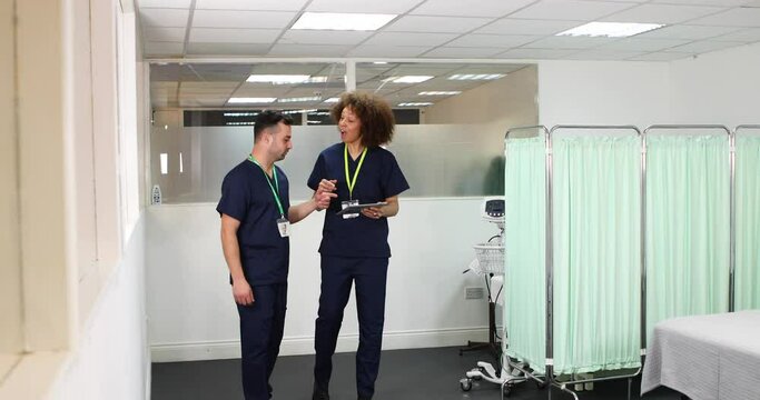 Male and female nurse discussing roster in hospital