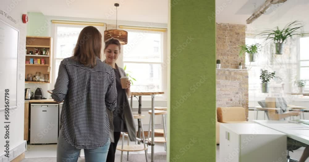 Wall mural Startup, business and worker in workspace, woman walk to kitchen after meeting with open concept and coffee break. Staff, work and start up company with modern office and professional working space.