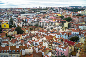 Obraz premium historic buildings of the old town of lisbon. Old colorful buildings, narrow streets, historic churches. Tiled roofs. View from the top of the tenement houses and monuments. Cloudy day 