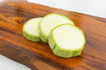 sliced fresh green cucumber on wooden cutting board