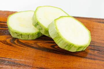 sliced fresh green cucumber on wooden cutting board