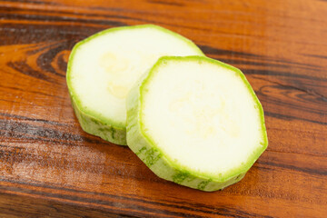 sliced fresh green cucumber on wooden cutting board