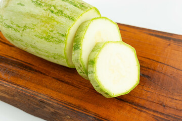 sliced fresh green cucumber on wooden cutting board