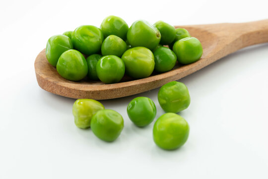 green peas isolated. fresh organic vegetables. on a wooden spoon