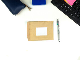 empty recycled paper stationery set mockup with white layout in the center and pen on the side, isolated against white office desk background