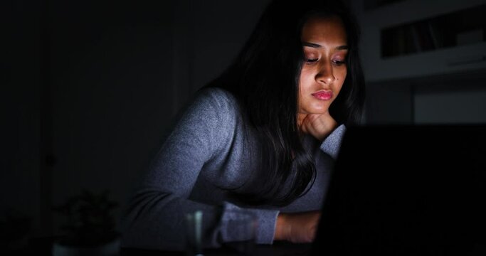 Young woman working late using laptop