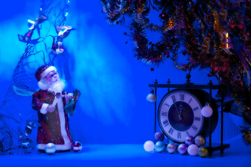 Santa Claus in blue light and vintage clock. New Year's Christmas toys,garlands