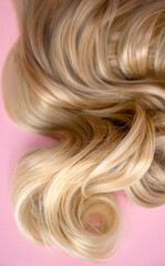 texture of beautiful glossy long hair. Twist female healthy hair. Hairdressing spa concept. strand of blond silky hair.