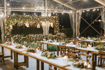 Fototapeta na wymiar Wedding reception night dinner setup table with beautiful flower decoration.