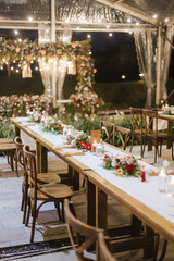 Wedding reception night dinner setup table with beautiful flower decoration.