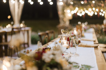 Wedding reception night dinner setup table with beautiful flower decoration.