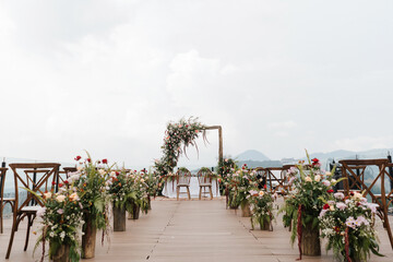 Beautiful outdoor wedding setup, clear sky, flower decoration, with mountain background view.