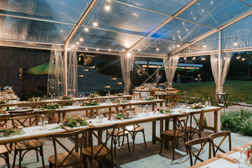 Wedding reception night dinner setup table with beautiful flower decoration.