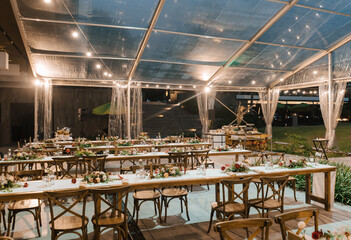 Wedding reception night dinner setup table with beautiful flower decoration.