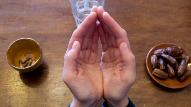 A young Muslim woman in a hijab is praying to glorify Allah and practice the Islamic faith in the mosque. Ramadan aid mubarak concept islam dates water fasting