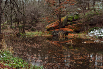 part of autumn
natural landscape with a view of space;
large stone boulders on the shore of an autumn forest lake