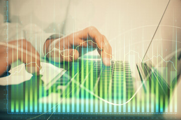 Double exposure of market chart with man working on computer on background. Concept of financial analysis.