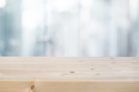 Selective focus.Top of wood table with blur window glass  background.
