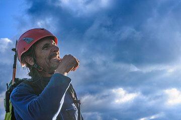 Climber with examining look, risk assessment, cloudy sky, isolated, copyspace