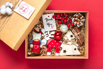 Handmade care package, seasonal gift box with toys, xmas decor on red table Personalized eco friendly basket for family, friends, girl for 24 December, Christmas, New Year day Flat lay