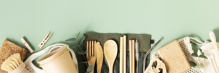 Banner Set of eco-friendly tableware and cleaning products on pastel green background, flat lay...