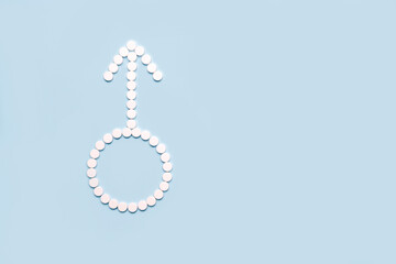 Medical pills in male symbol shape on a light blue background. Concept fmale health, contraception,...