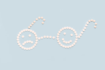 Obraz premium A sad and a happy face made of pills..Sick and healthy concept.The concept of antidepressants and healing