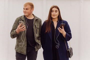 Happy Caucasian couple using a Smart Phone outdoors in the city