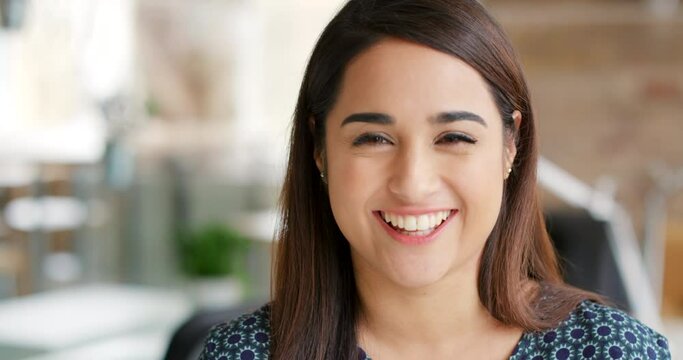 Business woman, face and happy with vision, mindset and motivation for success. Portrait smile of a young entrepreneur or corporate professional with bokeh and background in startup company in spain