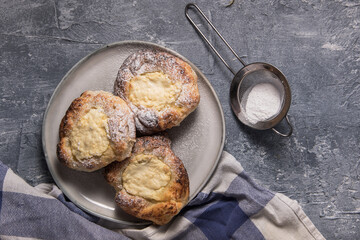 Patties with cottage cheese on a marble table. Russian pastry (vatrushka)