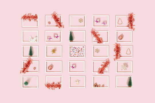 White frames decorated with pink Christmas ornaments on bright pastel pink background. Flat lay advent concept. Creative New Year idea.