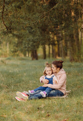 Naklejka na ściany i meble beautiful and happy mother and daughter have a good time in the forest