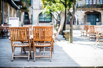 Fototapeta na wymiar Terrace of a cafeteria with wooden chairs and tables in Pontevedra, Galicia (Spain)