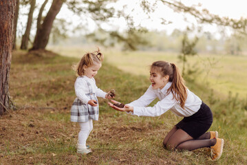Fototapeta premium beautiful and happy mother and daughter have a good time in the forest