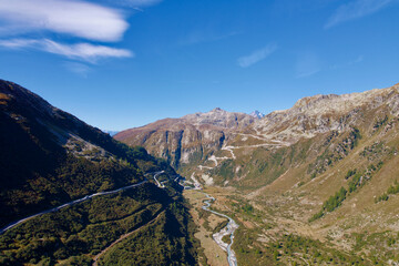 Mountain panorama with Rhone River in the Swiss Alps at region of mountain pass Furkapass with serpentine road of Grimselpass in the background. Photo taken September 12th, 2022, Goms, Switzerland.