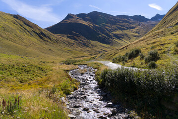 Scenic view of mountain panorama with Muttenbach creek in the Swiss Alps at famous Swiss mountain pass Furkapass on a sunny late summer day. Photo taken September 12th, 2022, Furka Pass, Switzerland.