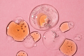 Group of gel serum smears  in different colors with bubbles on pink background.