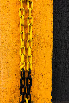 Yellow and black chain hanging on yellow and black wall