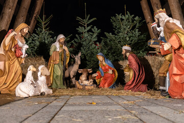 Fototapeta na wymiar Model of the Traditional Nativity scene with a holy family in Bethlehem and the baby Jesus lying in a manger at the Christmas market.
