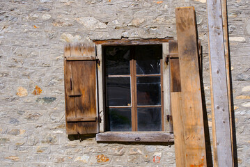 Open wooden shutters at abandoned traditional building at mountain hamlet Gletsch, Canton Valais, on a sunny late summer day. Photo taken September 12th, 2022, Gletsch, Switzerland.