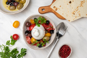 Burrata cheese salad with tomatoes, olives and olive oi	