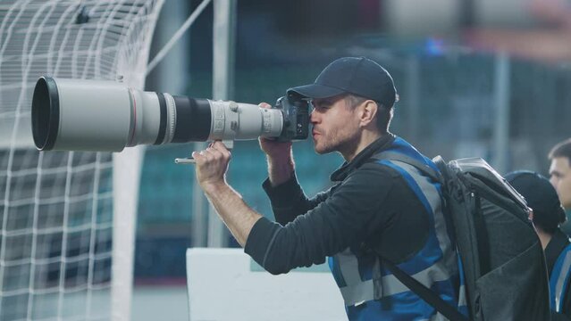 Professional Sports Photographer with Big Lens Shooting Football Championship on a Stadium. International Cup, World Tournament Sports Event Photography and Media Finals Coverage. Medium Close-up