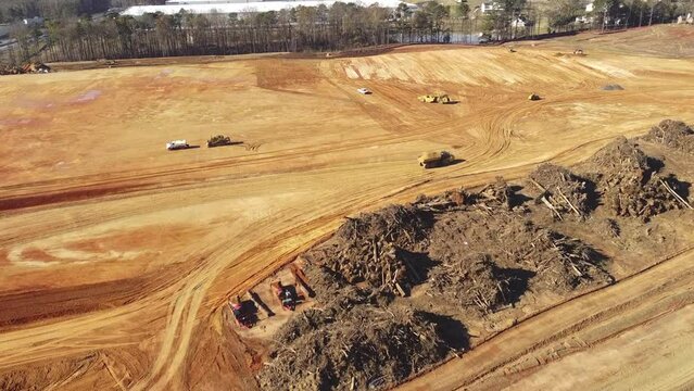 Aerial view busy heavy machines working on earthmoving works for raft foundation large warehouse construction project near Gravel Springs Road in Buford, Georgia, US. Industrial transportation video