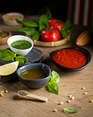 Mix of classic italian sauces: tomato, lemon and pesto in rustic style close up.