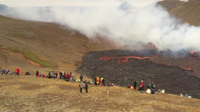 Aerial video of people watching on flowing lava 