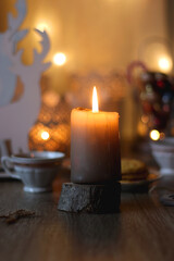 Two types of cookies, cups of tea or coffee, various Christmas decorations and lit candles. Cozy Christmas atmosphere at home. Selective focus.