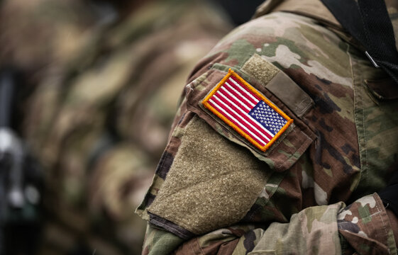 US Army soldiers uniform. Close up photo with the United States of America flag on a military soldier uniform with the gun next to it. Military industry detail concept photo.