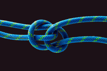 durable colored rope for climbing equipment on a dark background. knot of braided cable. item for tourism and travel