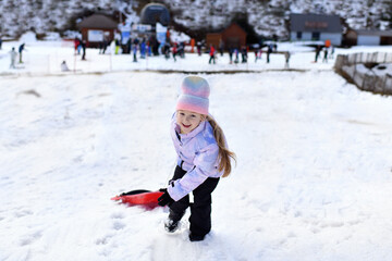 A girl with snow bob sledding in the snow